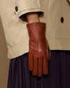 Cognac brown leather glove close-up with small embroidered motif on back
