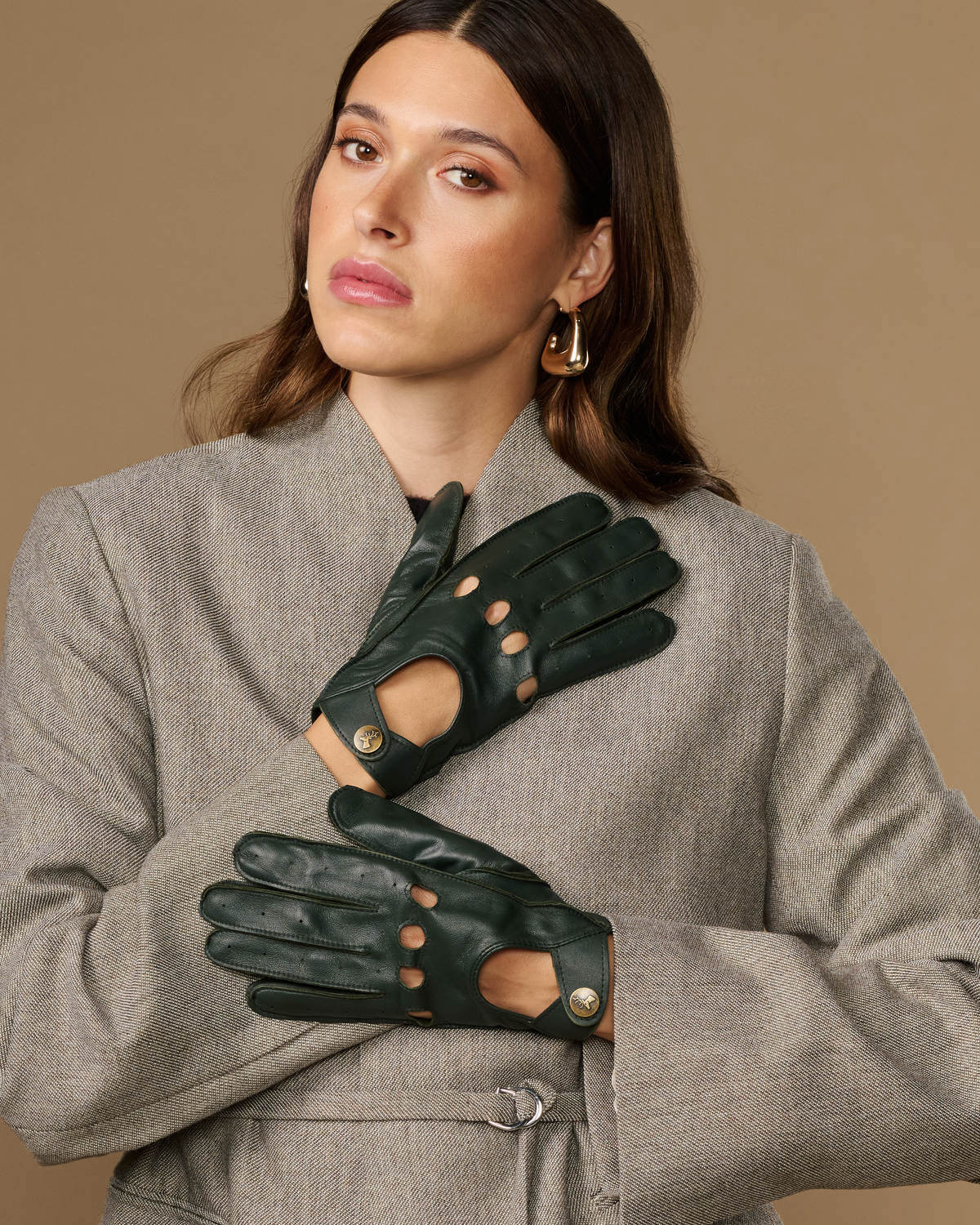 Dark green leather driving gloves with studded button details and finger cutouts