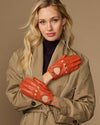 Women's orange lambskin driving gloves with touchscreen fingertips, snap wrist