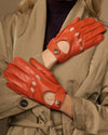 Women's orange lambskin driving gloves, perforated fingertips and snap-button wrist