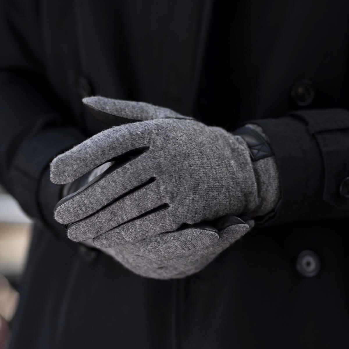 Close-up of grey fleece-lined gloves with curved finger seams and smooth leather