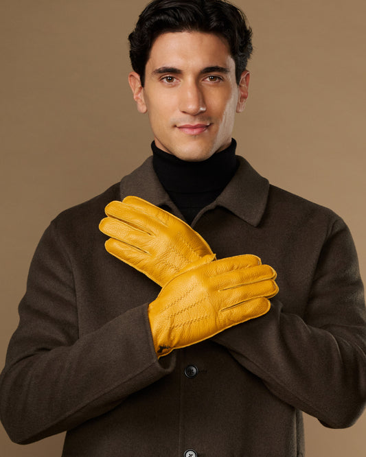 Yellow leather gloves on model, two gloves clasped at chest