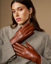 Extra-long cognac leather gloves with rabbit-fur cuffs, layered close-up
