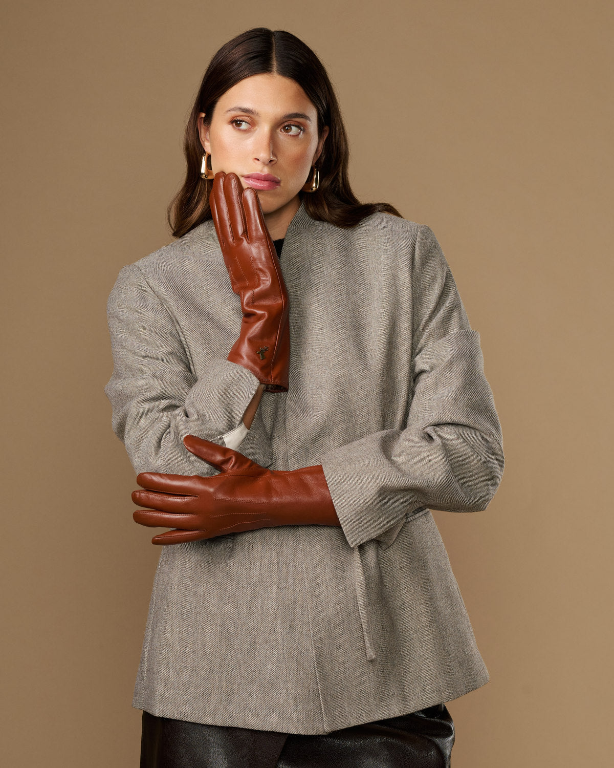 Extra-long cognac leather gloves with fur-lined cuffs, worn