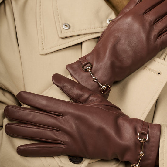 Dark brown lambskin gloves with gold-tone buckle hardware and shaped finger panels