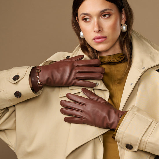 Brown leather gloves with gold-tone buckle accents and smooth stitched fingertips