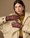 Brown leather gloves with gold-tone buckle accents and smooth stitched fingertips