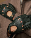 Dark green lambskin driving gloves close-up with perforated finger panels and button