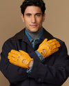 Pair of men's yellow lambskin driving gloves with denim lining and perforated knuckles