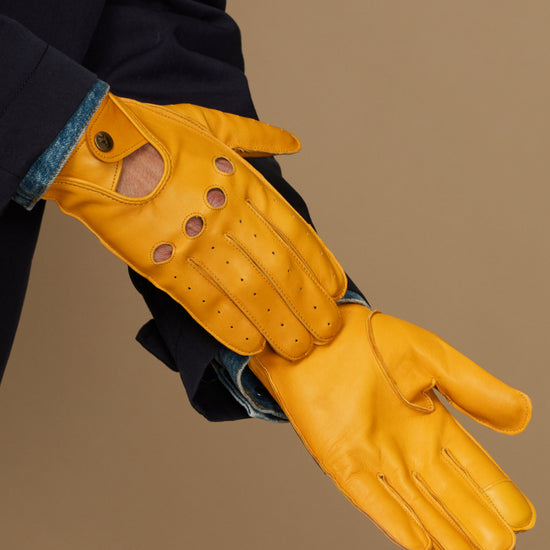 Men's yellow lambskin glove on wrist, stitched finger panels and buttoned cuff