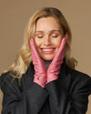 Women’s pink leather gloves covering hands near face, showing clean stitched fingertips