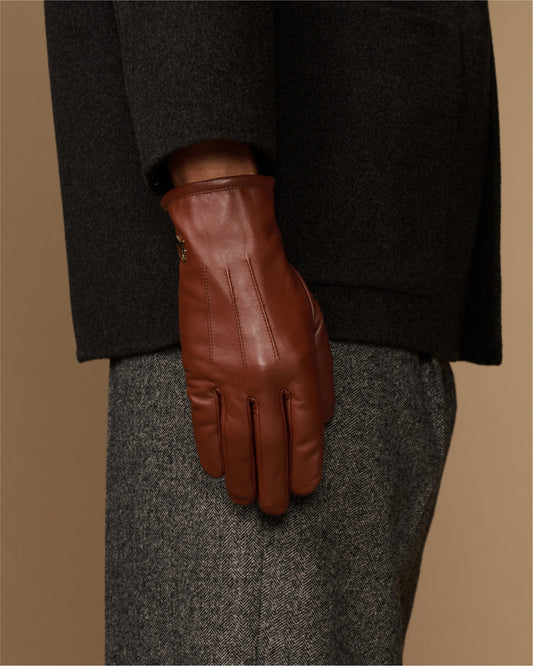 Cognac leather glove close-up with fleece-lined cuff and stitched finger panels