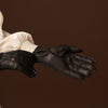 Close-up of black leather women’s gloves, textured finish and stitched fingers