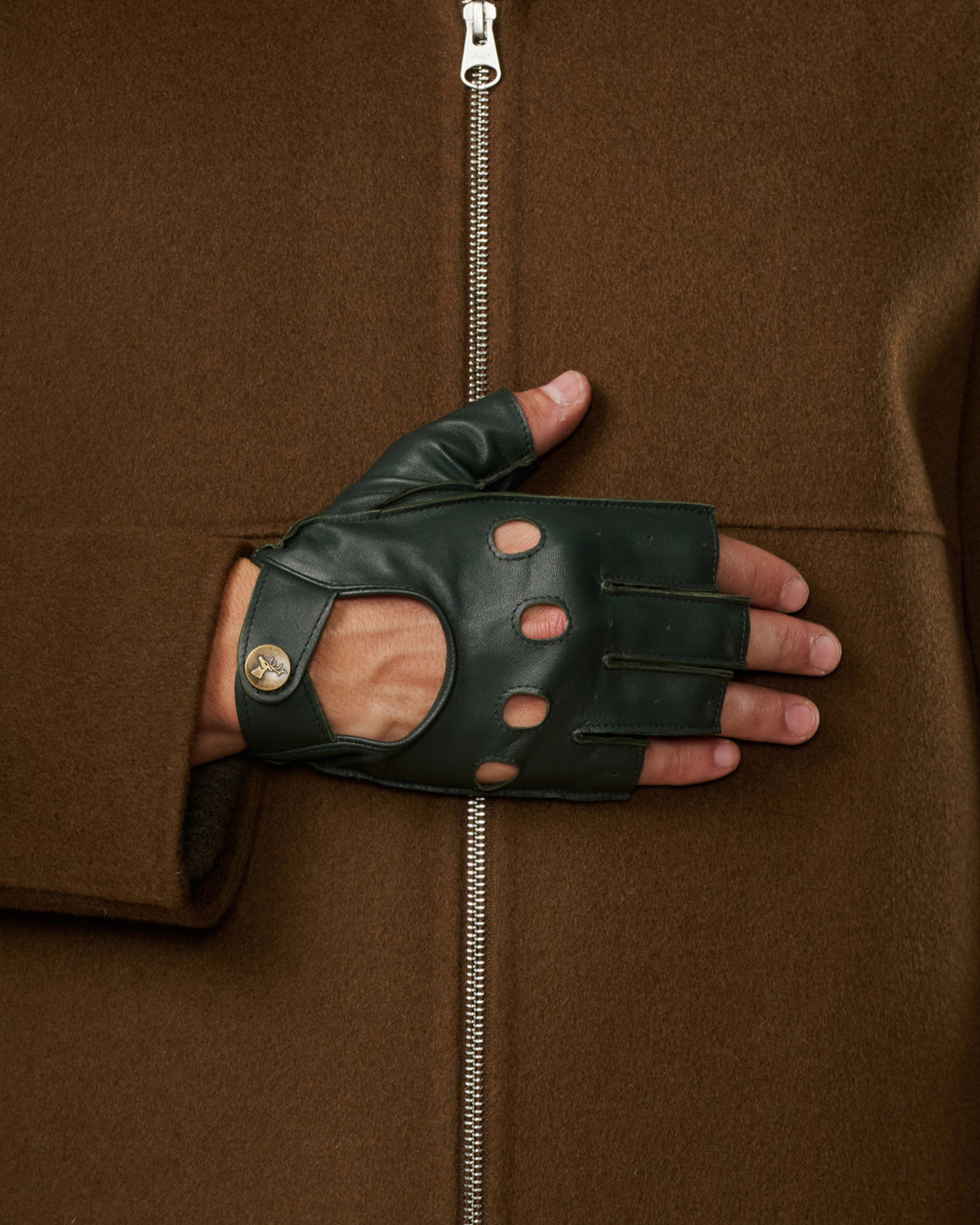 Dark green fingerless lambskin glove with perforations and a buttoned wrist strap