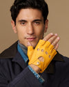 Yellow fingerless driving glove with perforated knuckles and snap cuff detail