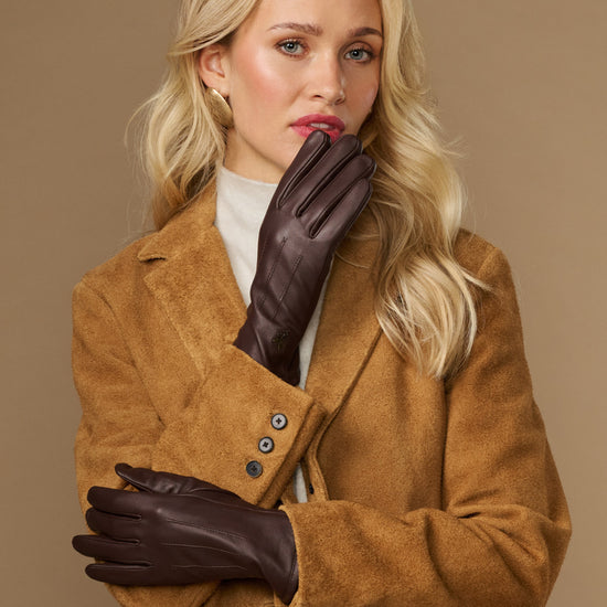 Brown leather gloves with fleece lining, worn and clasped hands front view