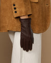 Brown leather gloves with fleece lining, one glove hanging in front view