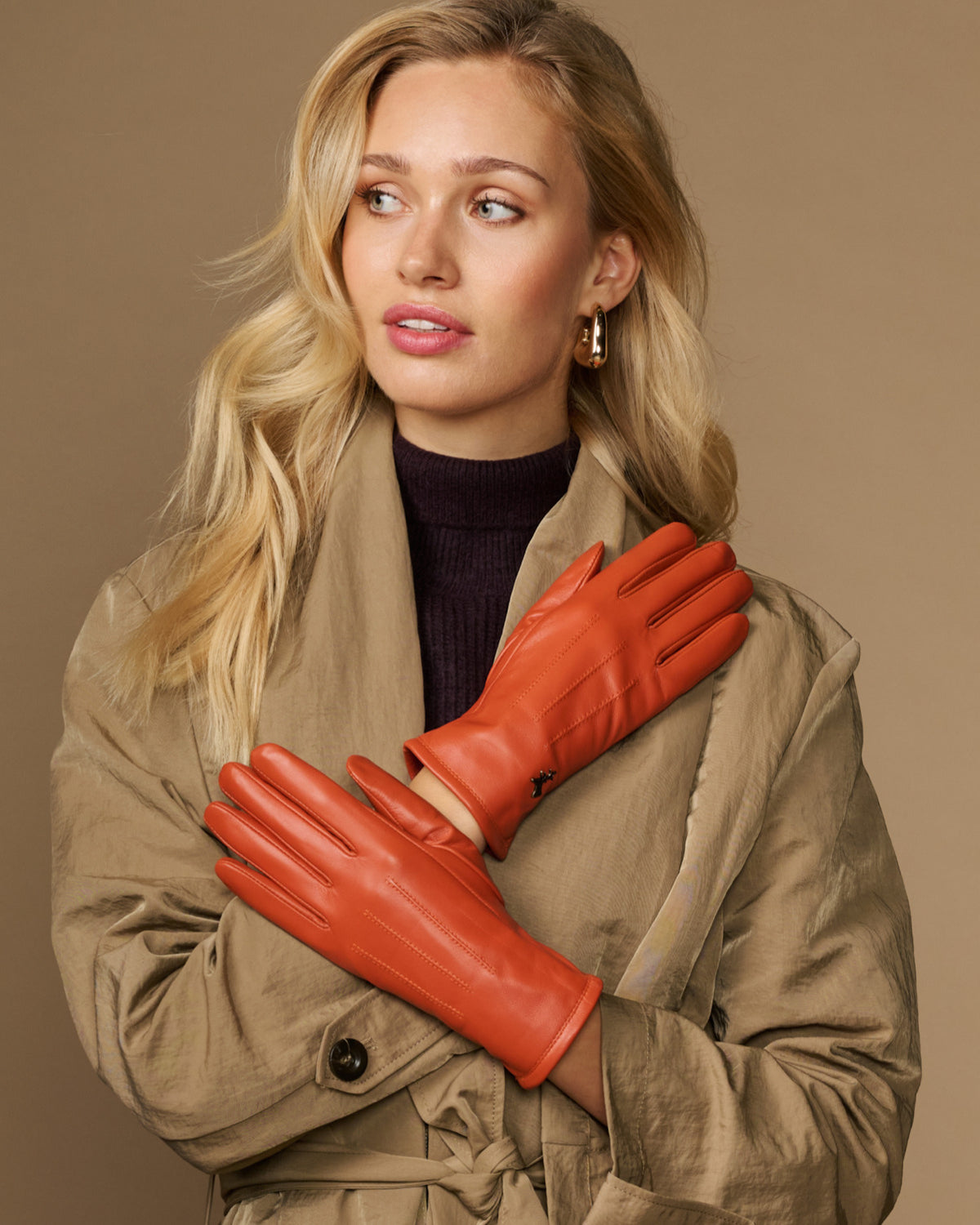 Orange sheepskin leather gloves with warm fleece lining, held together at chest