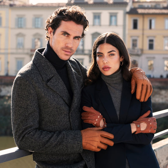 Cognac leather gloves worn by both hands, cuff edge visible