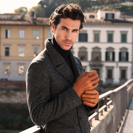Man in dark coat wearing cognac brown peccary leather gloves