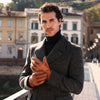 Man holding hands together wearing cognac brown peccary leather gloves