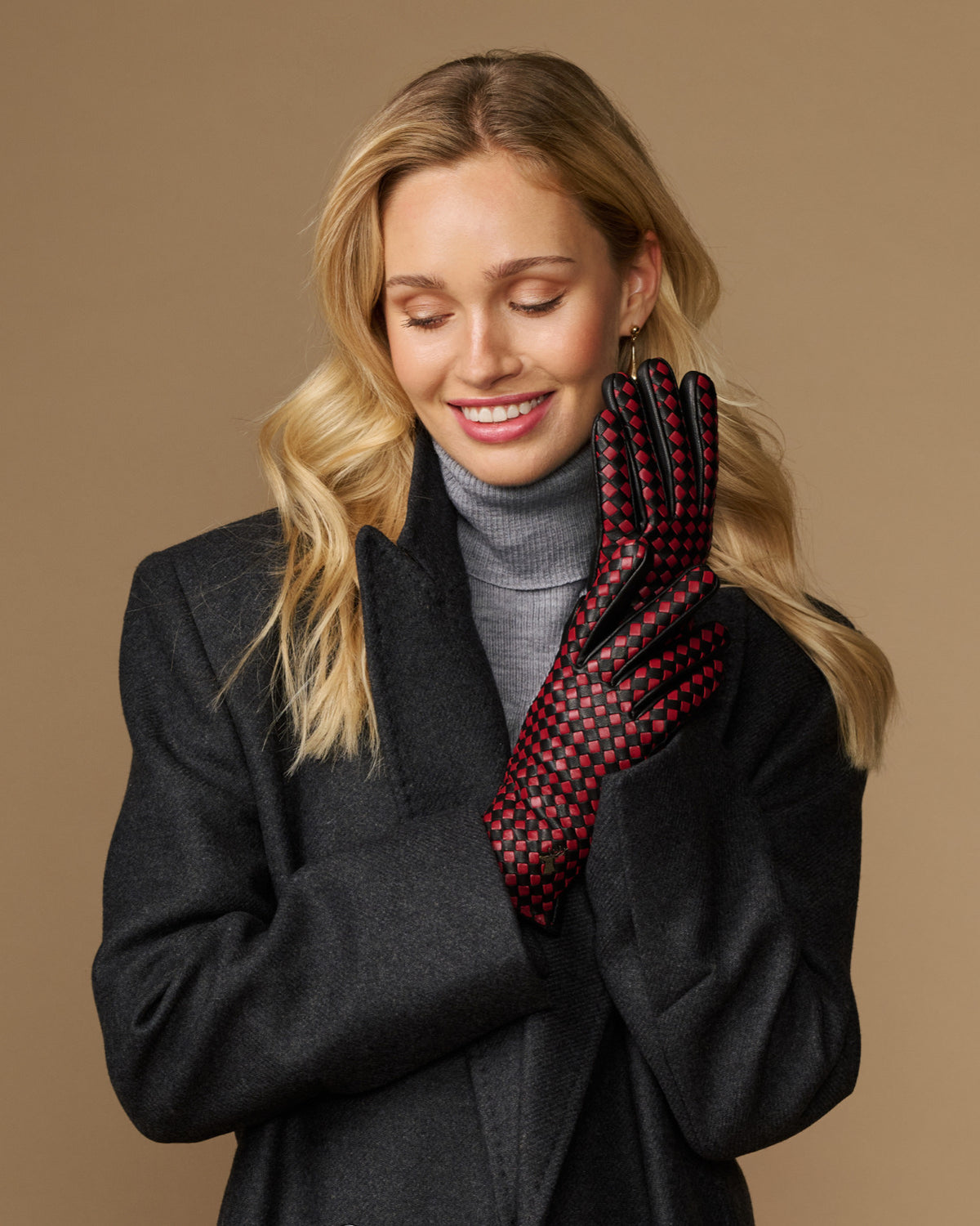 Women's black leather glove with red-and-black checkered interior, partial view