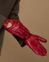 Men's red leather driving gloves, side view with open thumb and stitched knuckles
