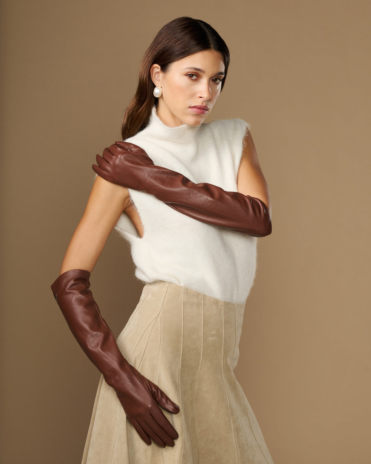 Women’s elbow-length brown lambskin leather gloves with silk lining, worn.