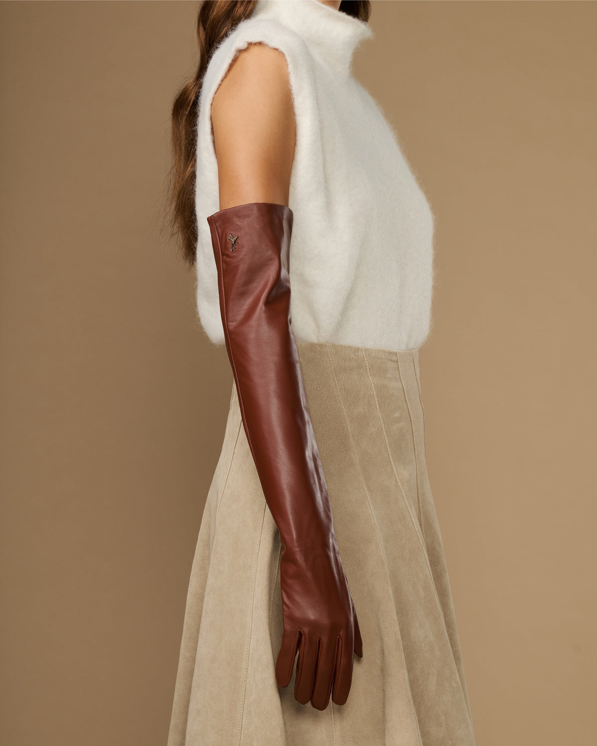 Chestnut brown leather opera glove on arm, long sleeve with fitted wrist cuff