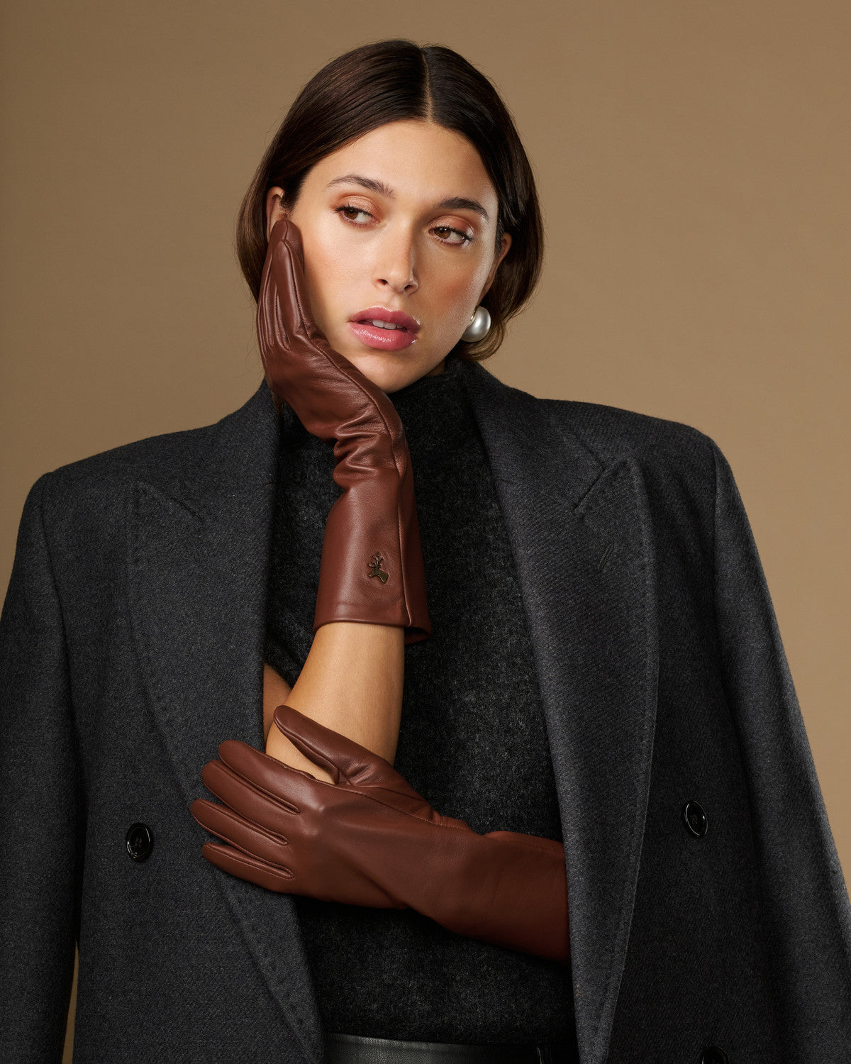 Brown mid-forearm lambskin gloves, detailed cuff and hand fit close-up
