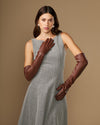 Women's chocolate-brown lambskin leather gloves, one hand raised with curved finger seams