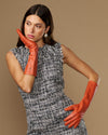 Women’s orange leather gloves with stitched emblem, palm and finger detail