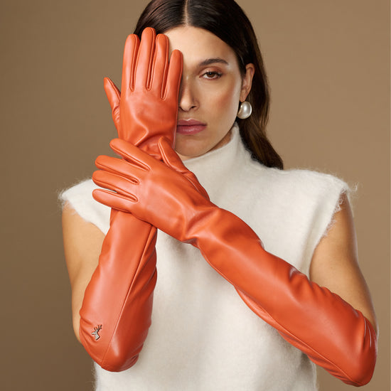 Pair of orange leather elbow gloves with smooth finish and curved finger seams