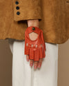 Orange fingerless glove with finger holes, thumb opening, and round logo wrist button