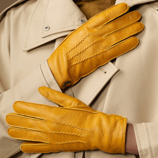 Close-up of yellow deerskin leather gloves with seam details on the knuckles