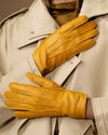 Close-up of yellow deerskin leather gloves with seam details on the knuckles