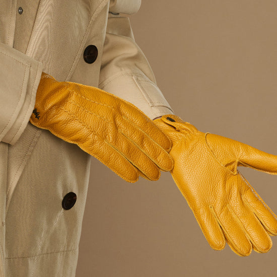 Yellow deerskin leather glove with textured grain, stitched fingers, and wrist cuff