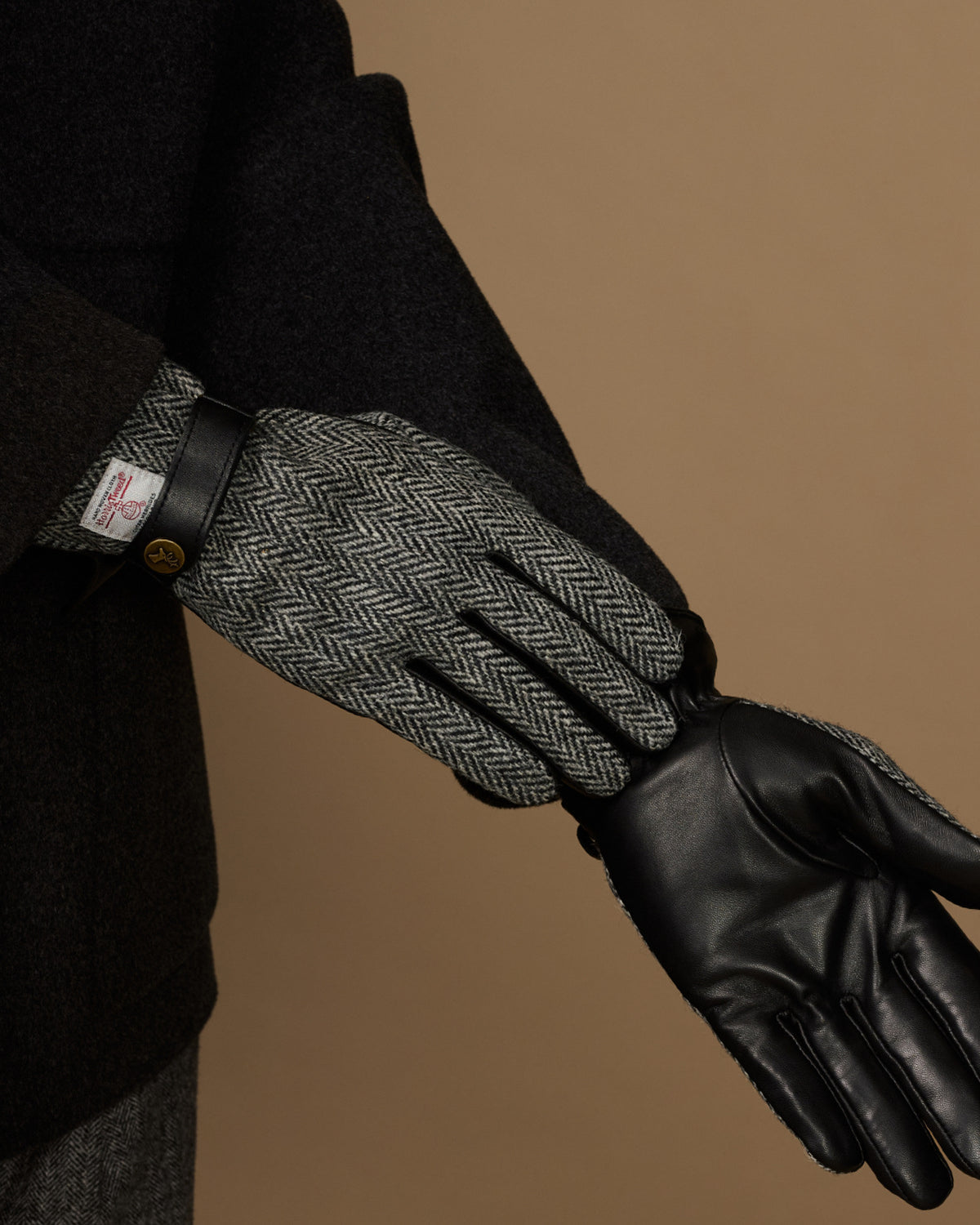 Men's gloves with gray herringbone interior and black leather hand section and cuff.