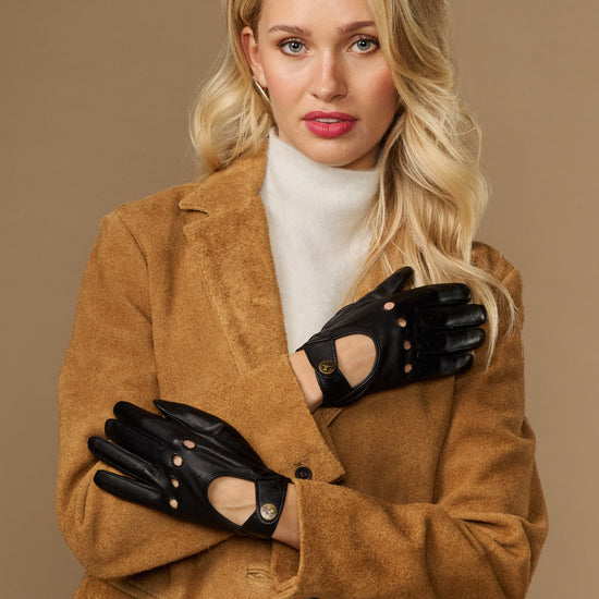 Black leather driving gloves with decorative snaps and elastic wrist opening.