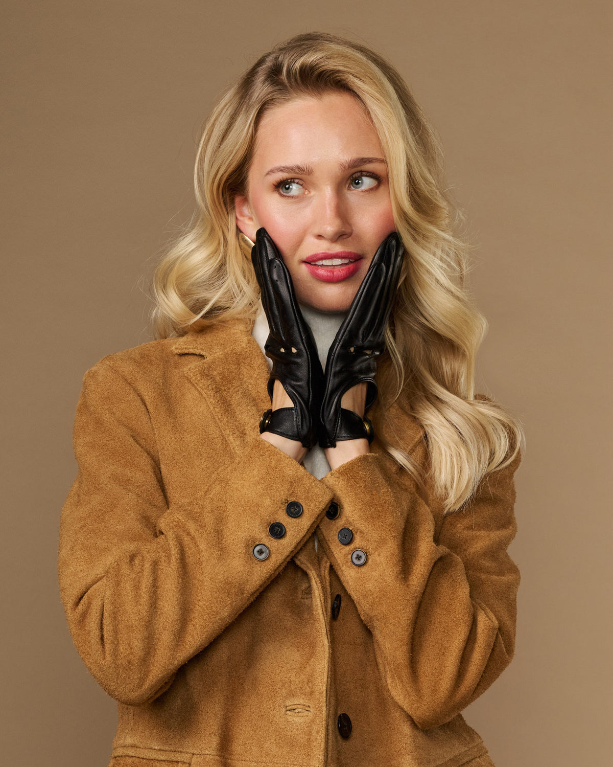 Black leather driving gloves with stud accents and elastic wrist cuffs.