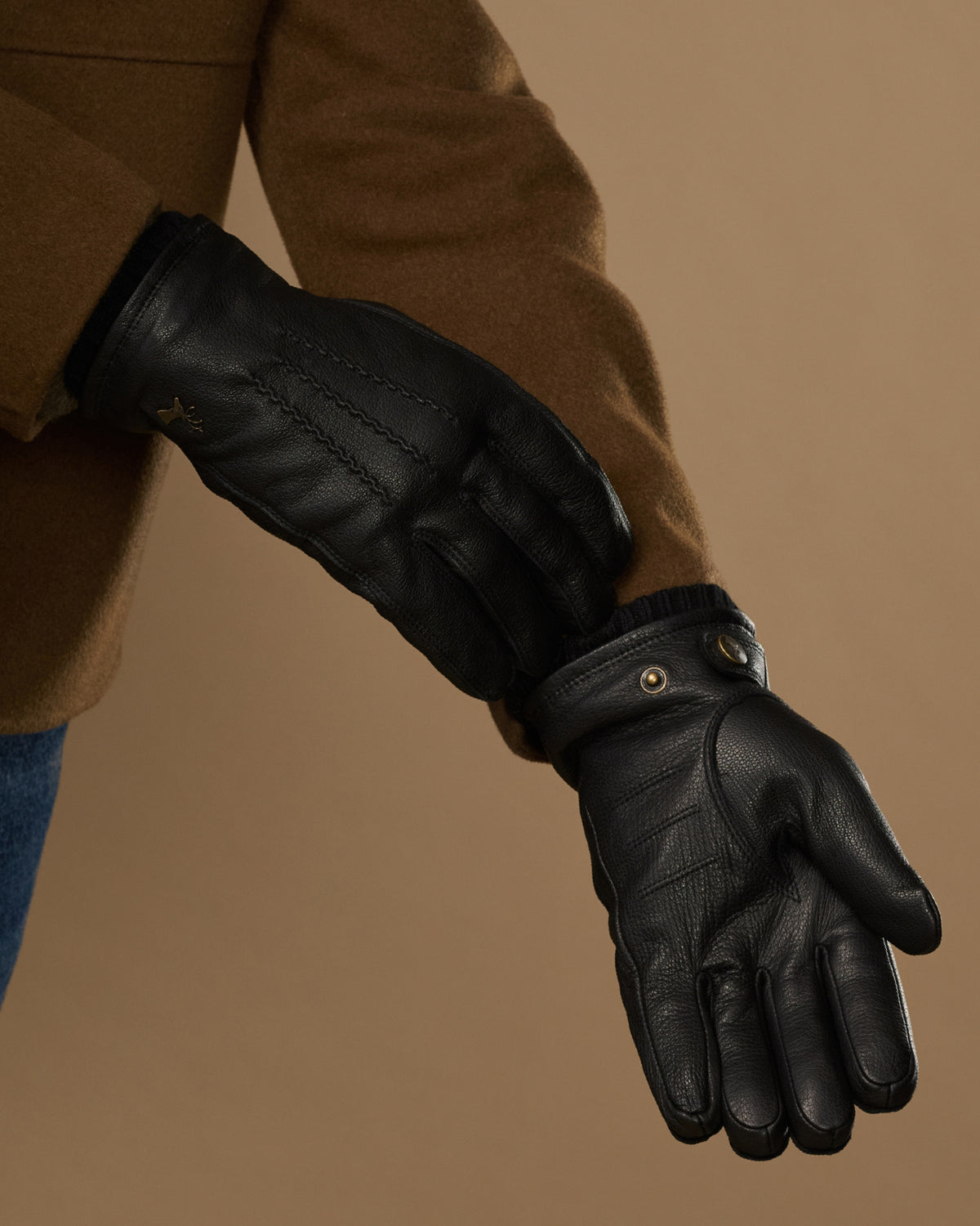 Black goatskin leather gloves with warm lining visible at cuff and press-stud