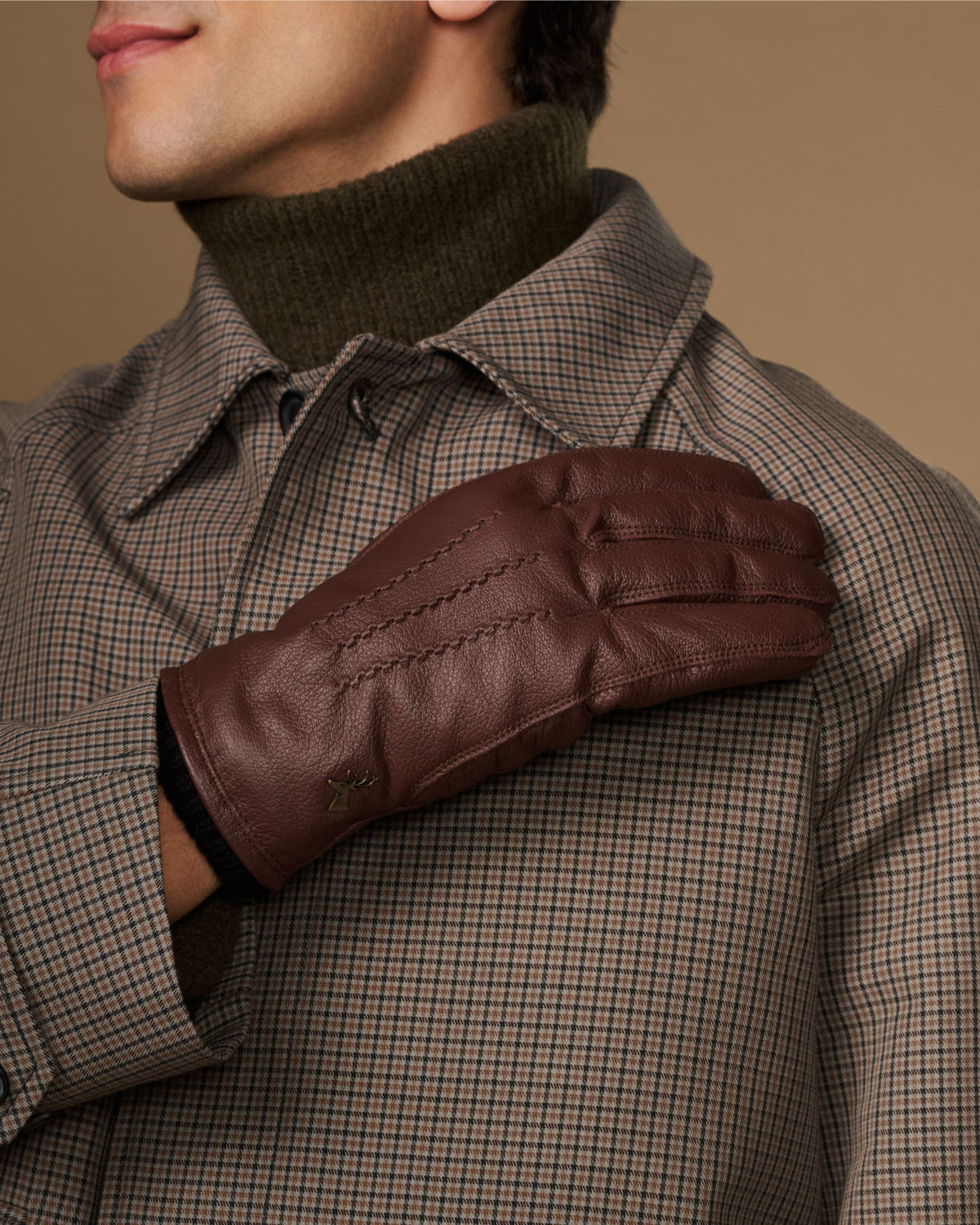Brown leather glove worn on arm with fleece-lined cuff