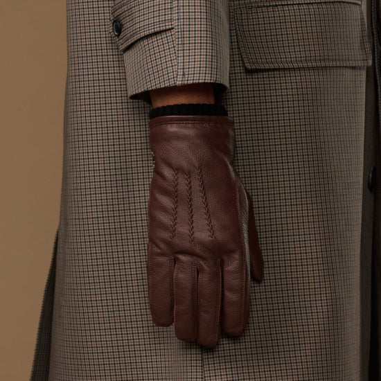 Brown leather glove cuff with black fleece lining and press-stud detail